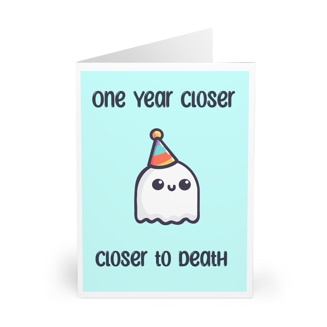 Funny and slightly dark birthday card featuring a smiling ghost in a party hat with the phrase 'One Year Closer to Death.' Ideal for friends with a morbid sense of humor who appreciate sarcastic cards - Baby Keo.