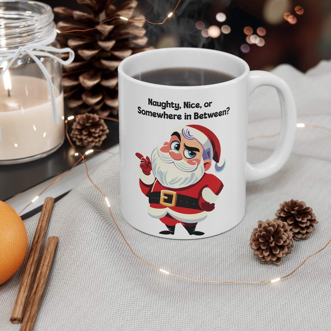 Funny Christmas mug featuring a sassy Santa and the phrase 'Naughty, Nice, or Somewhere in Between?' Perfect for holiday coffee or hot chocolate, this ceramic mug brings humor to festive mornings. Available in 11oz and 15oz sizes