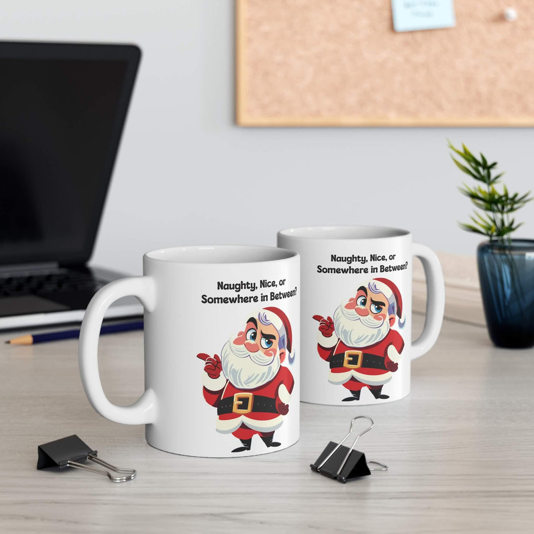 Funny Christmas mug featuring a sassy Santa and the phrase 'Naughty, Nice, or Somewhere in Between?' Perfect for holiday coffee or hot chocolate, this ceramic mug brings humor to festive mornings. Available in 11oz and 15oz sizes