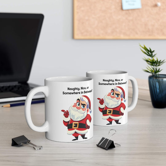 Funny Christmas mug featuring a sassy Santa and the phrase 'Naughty, Nice, or Somewhere in Between?' Perfect for holiday coffee or hot chocolate, this ceramic mug brings humor to festive mornings. Available in 11oz and 15oz sizes