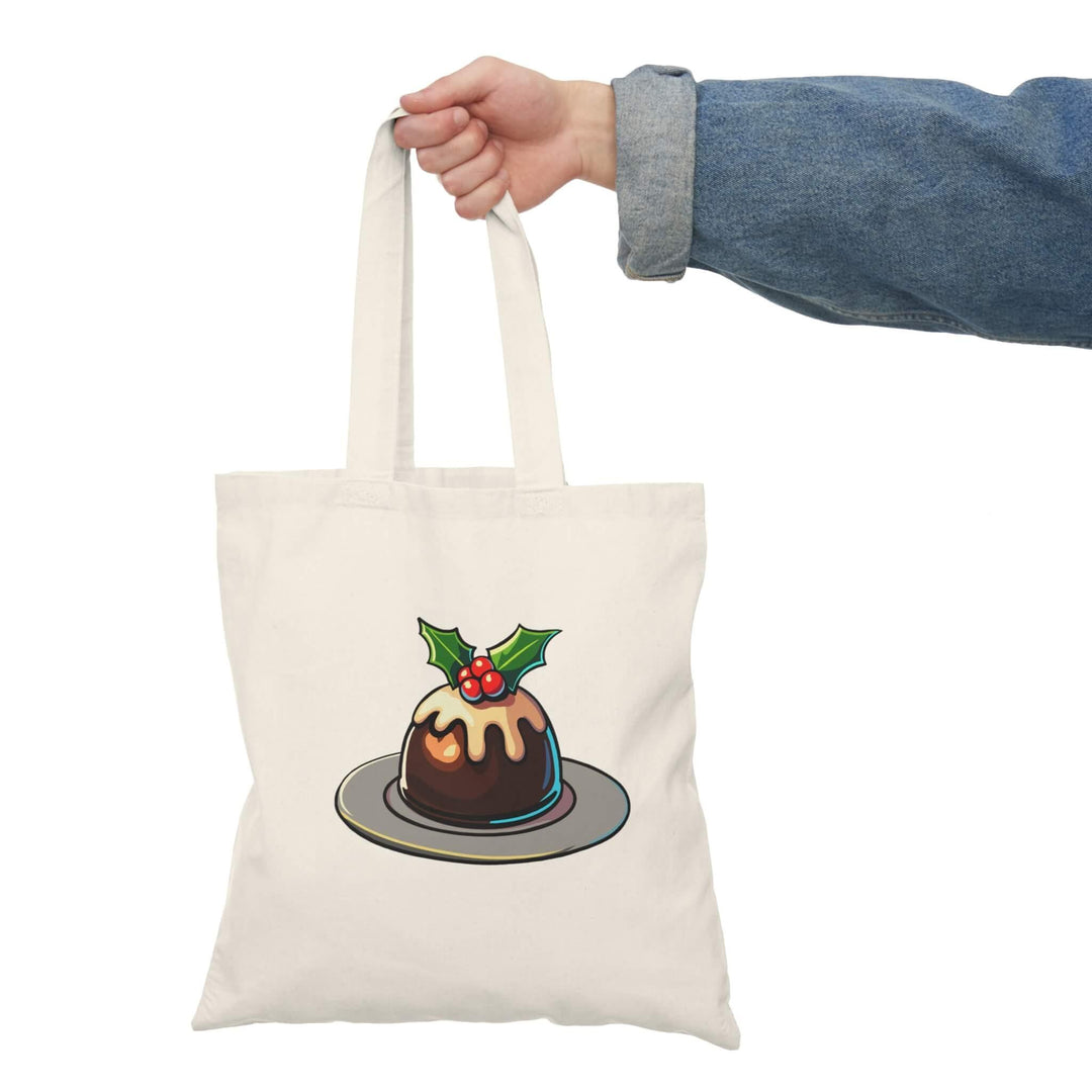 Festive Christmas pudding tote bag featuring a traditional pudding with holly and icing. Made from 100% recycled cotton, perfect for holiday shopping, gift-carrying, and adding seasonal charm to daily errands