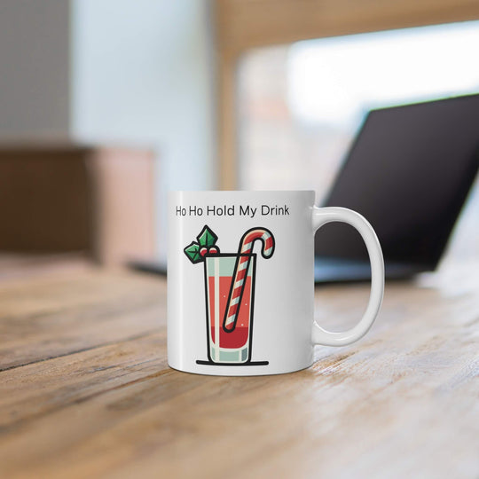 Ho Ho Hold My Drink’ 11oz ceramic Christmas cocktail mug with festive drink, candy cane stirrer, and holly, perfect for holiday sips