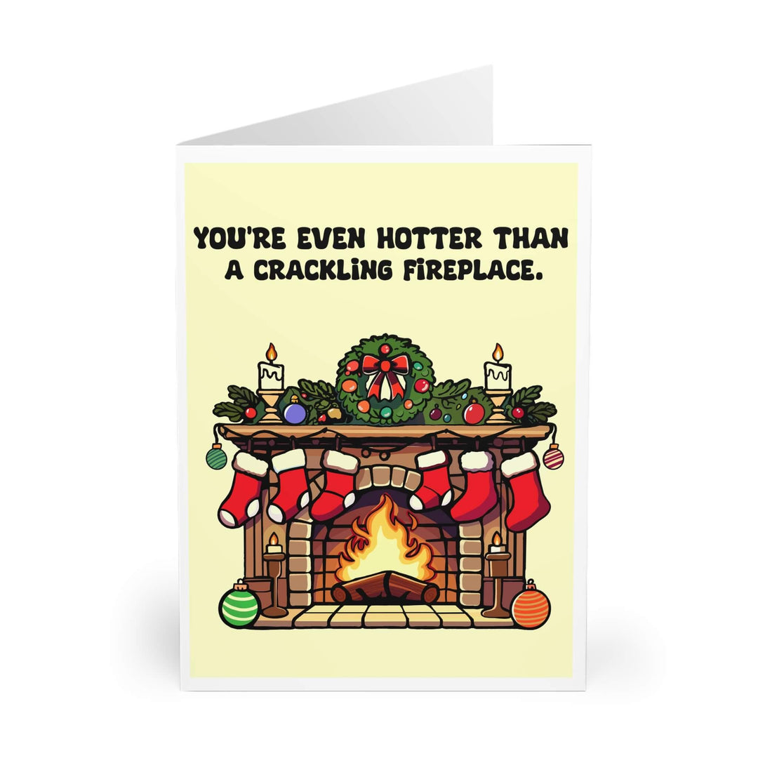 You’re Even Hotter Than a Crackling Fireplace’ Christmas card with cozy fireplace scene, decorated mantel, stockings, and a roaring fire. Perfect for adding warmth to holiday greetings.