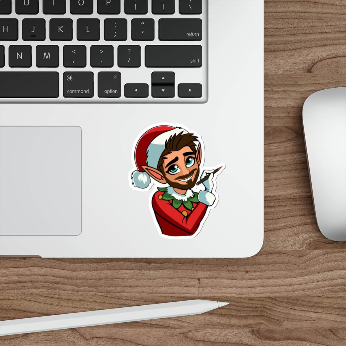 A festive sticker featuring a charming Christmas elf with a red Santa hat, green elf attire, and a playful pose. Displayed on a laptop for a stylish and fun holiday vibe. Available as a single sticker or in packs of three or six.