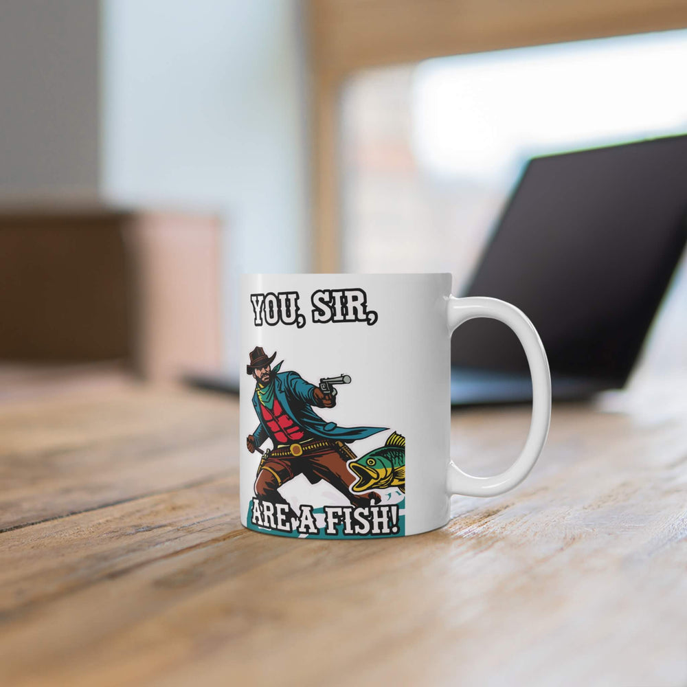 A humorous 11oz ceramic mug featuring a vibrant design of a cowboy aiming at a fish with the text "You, Sir, Are a Fish!" Perfect for coffee lovers with a quirky sense of humor, featuring a glossy finish, microwave and dishwasher-safe.