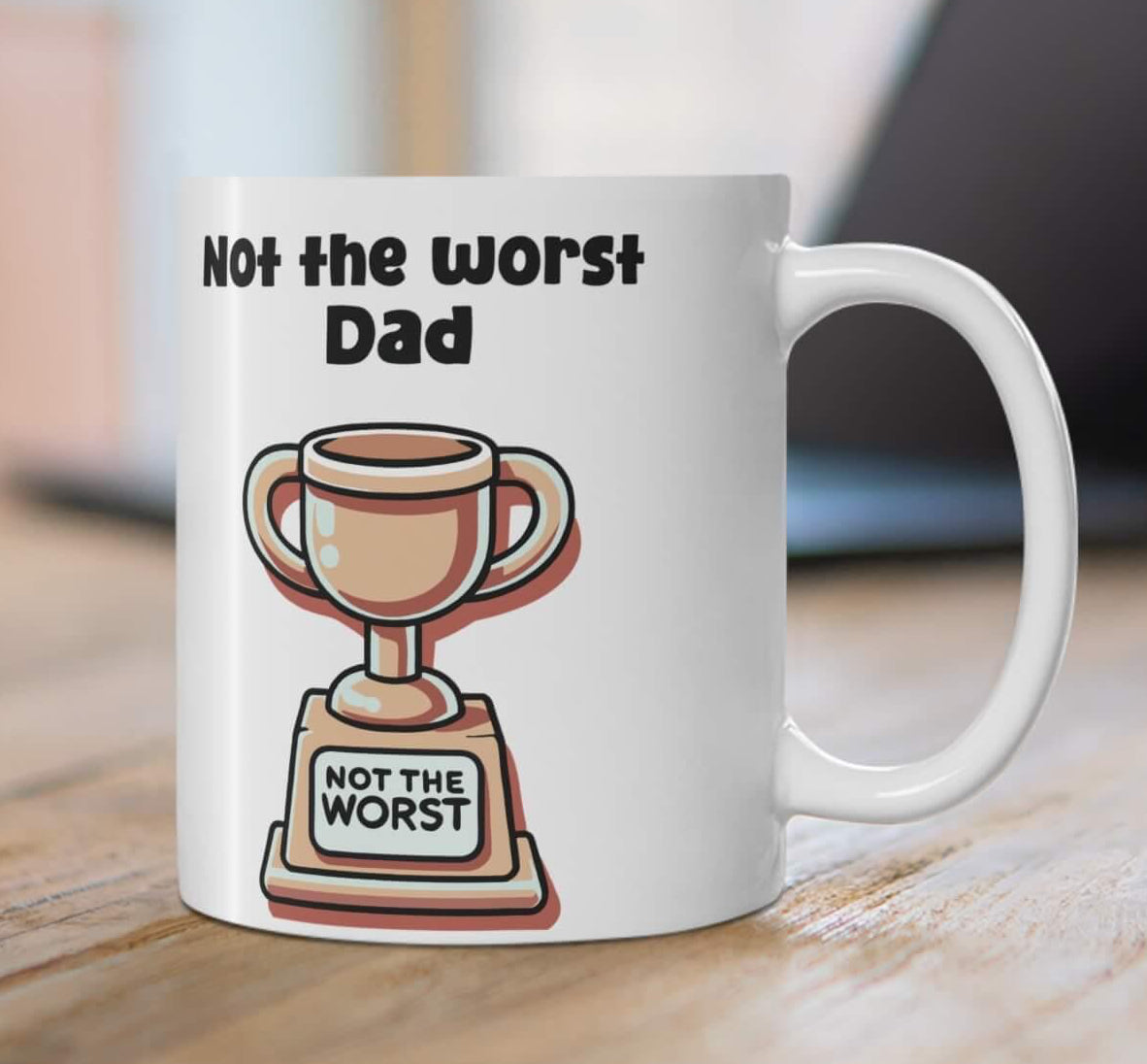 White ceramic mug with 'Not the Worst Dad' and a trophy design, ideal for gifting, 11 oz capacity, microwave and dishwasher safe.