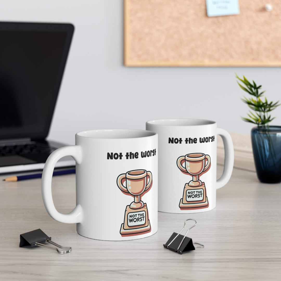 White ceramic mug with 'Not the Worst Dad' and a trophy design, ideal for gifting, 11 oz capacity, microwave and dishwasher safe.