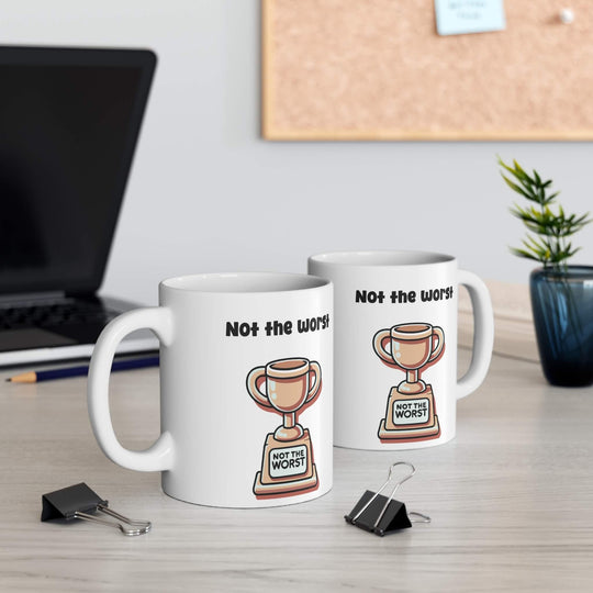 White ceramic mug with 'Not the Worst Dad' and a trophy design, ideal for gifting, 11 oz capacity, microwave and dishwasher safe.