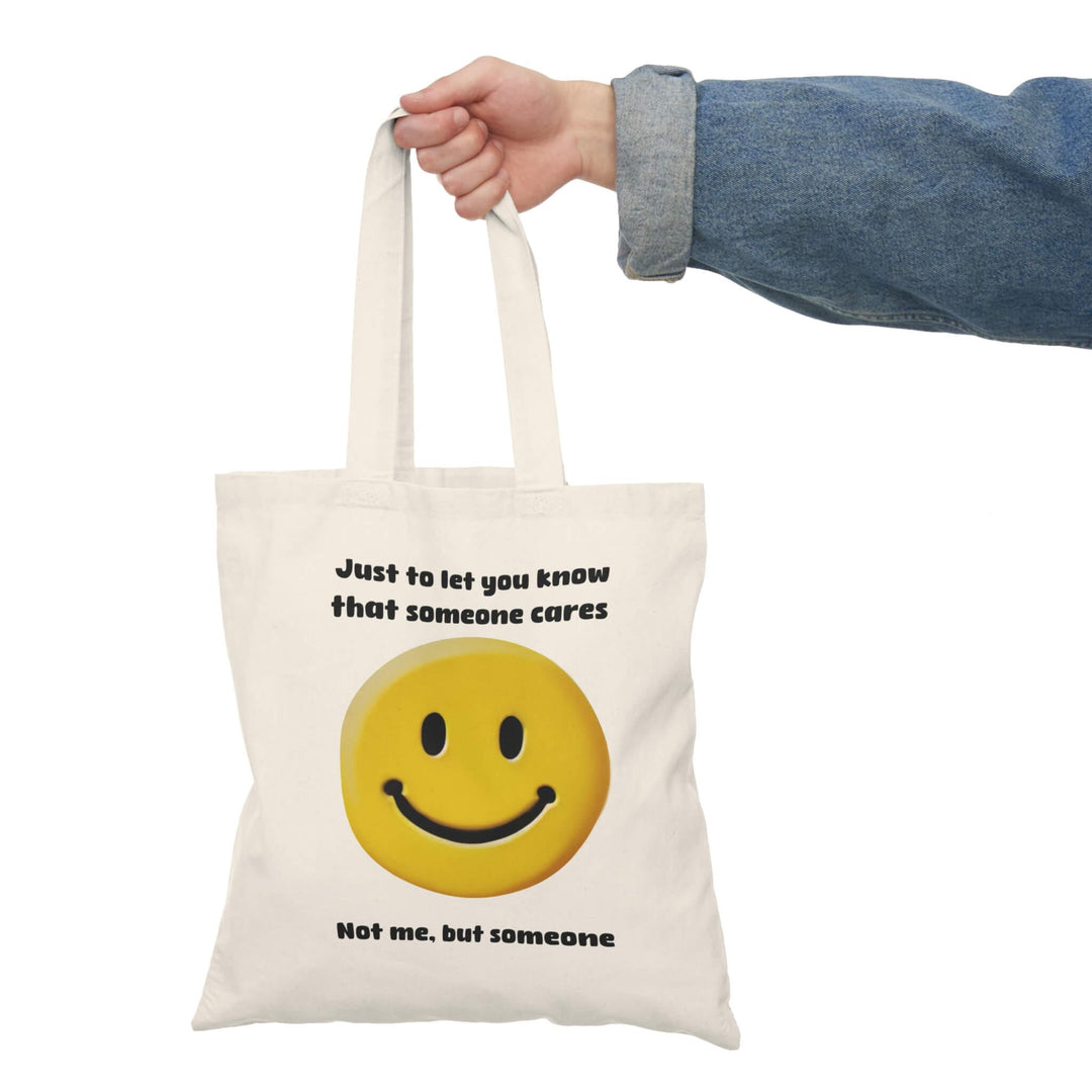 Recycled cotton tote bag with a cheeky smiley face and the humorous message, 'Just to let you know that someone cares. Not me, but someone
