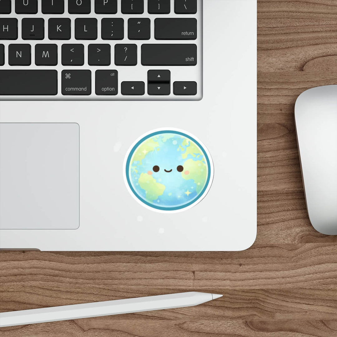 Cute pastel Earth sticker with a smiling face and soft sparkles, kawaii style vinyl decal placed on a laptop surface.