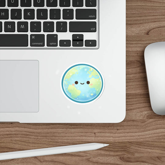 Cute pastel Earth sticker with a smiling face and soft sparkles, kawaii style vinyl decal placed on a laptop surface.
