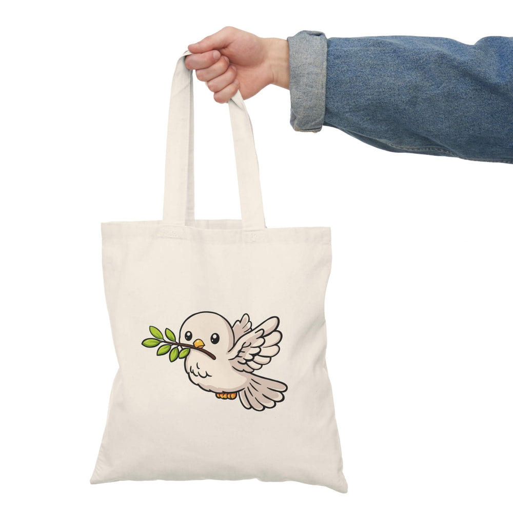 Tote bag with a bird design held by a person wearing a denim jacket.