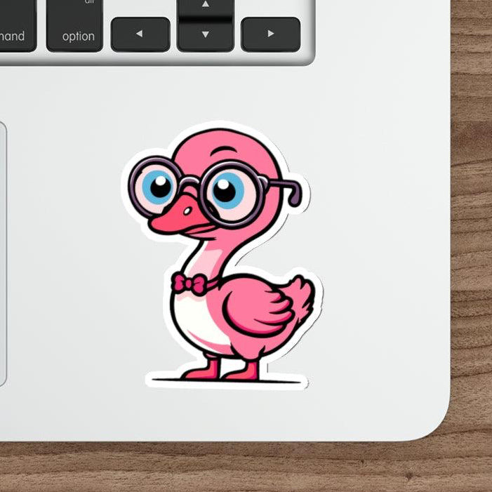 A pastel pink sticker of a cartoon goose with glasses placed on a laptop next to a computer mouse.