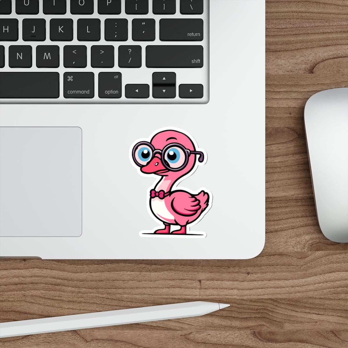 A pastel pink sticker of a cartoon goose with glasses placed on a laptop next to a computer mouse.