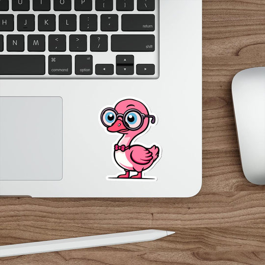 A pastel pink sticker of a cartoon goose with glasses placed on a laptop next to a computer mouse.