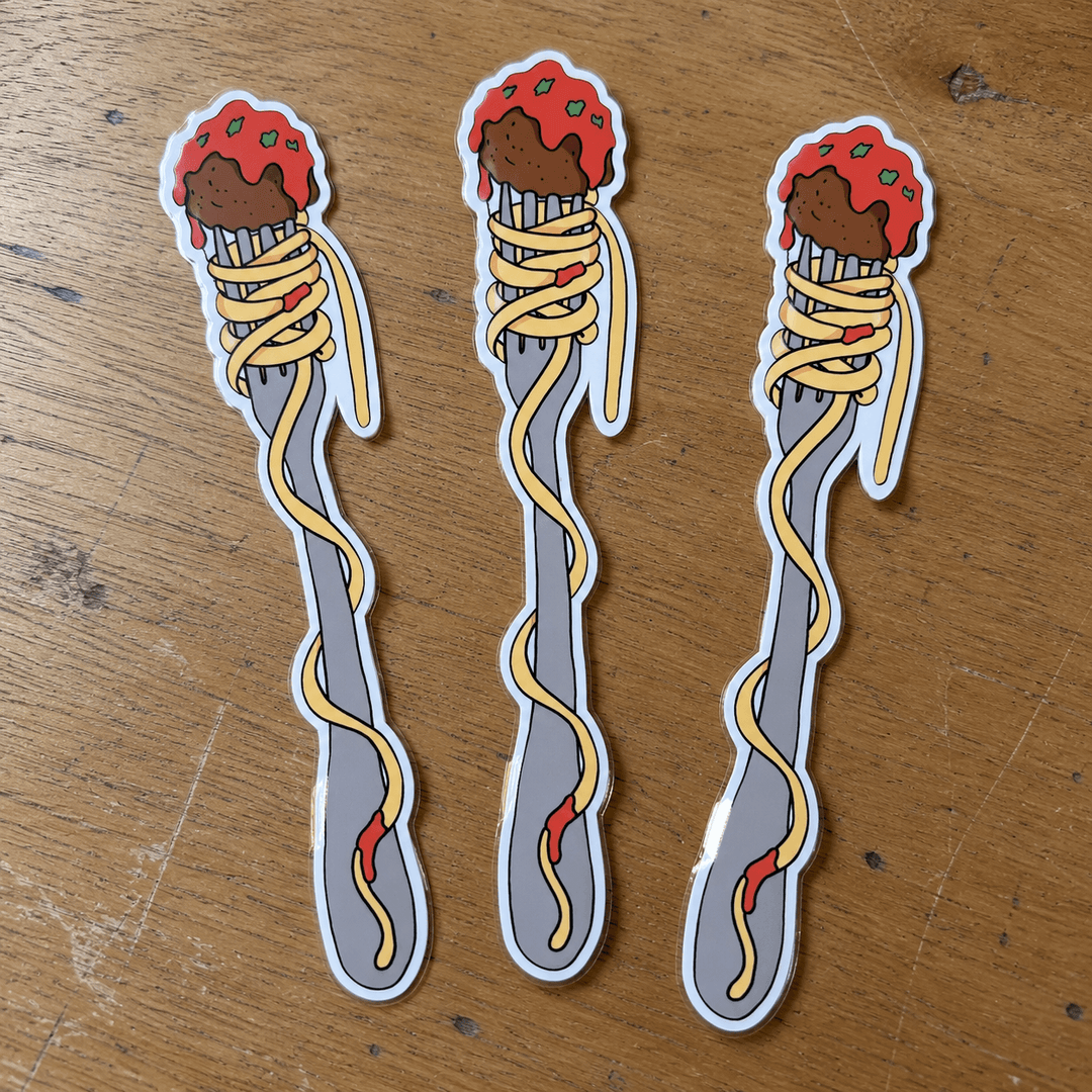 Three identical die-cut stickers of a fork wrapped in spaghetti with meatballs, displayed on a wooden tabletop.