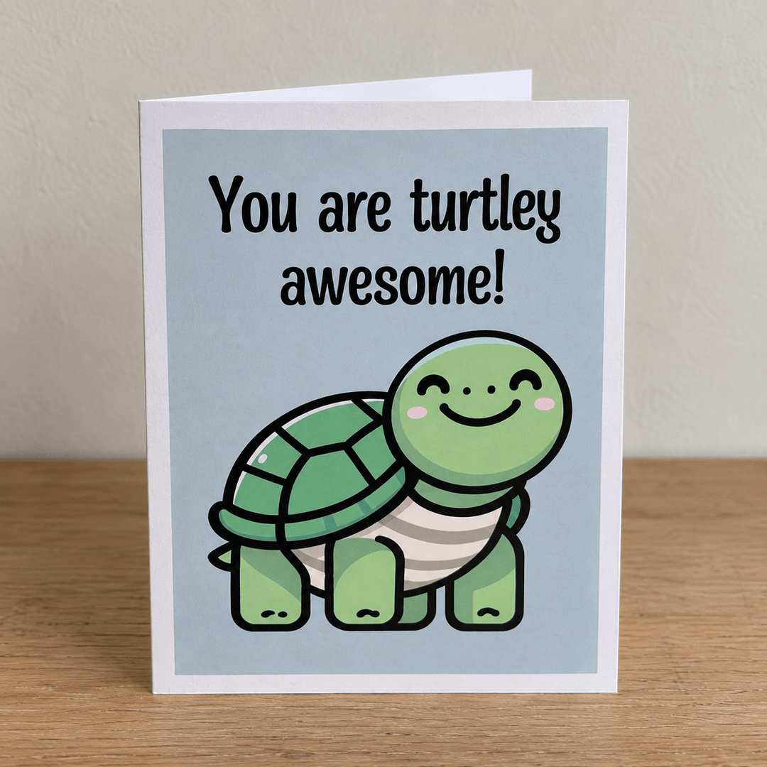 A folded greeting card standing upright on a wooden surface against a light beige wall. The card front shows a light blue background with the text &