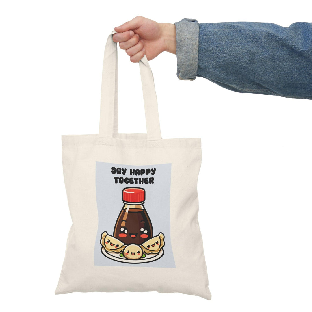 A natural tote bag showcasing a charming graphic of a soy sauce bottle and sushi, with the text 'Soy Better Together.' This punny design appeals to food lovers and adds a delightful touch to dining experiences.