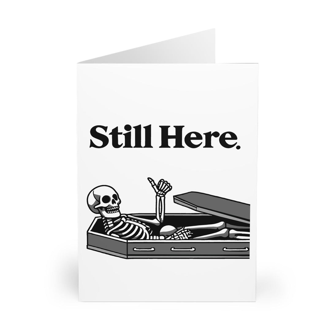 Playful card showing a relaxed skeleton with the phrase 'Still Here.' A cheeky way to send greetings or celebrate resilience - Baby Keo.