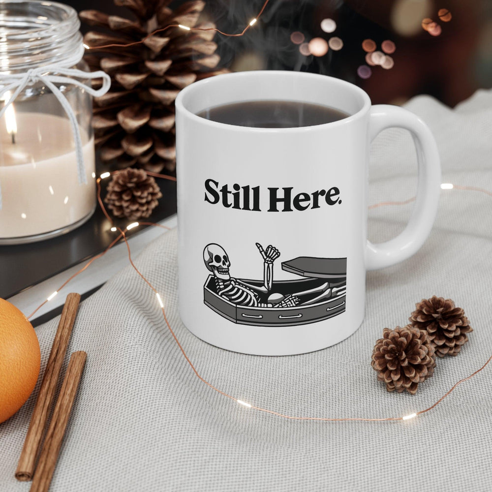 Minimalistic white ceramic mug with the text 'Still Here' and a simple design, perfect for a subtle yet thoughtful coffee companion