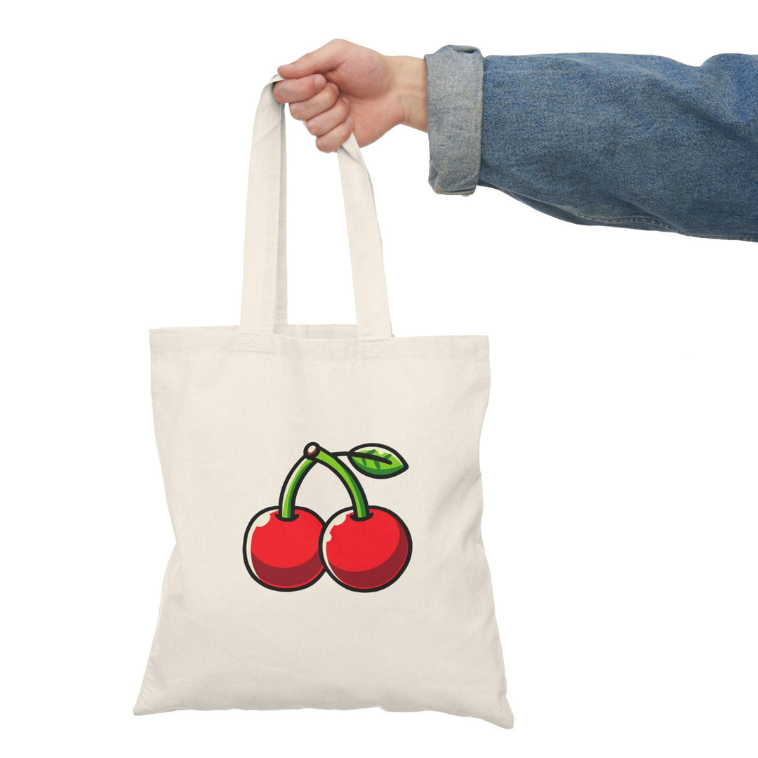 Tote bag featuring a charming design of vibrant red cherries against a soft background. The playful illustration captures the essence of summer and adds a fresh touch to your everyday style, making it a perfect accessory for fruit lovers and anyone seeking a pop of color."