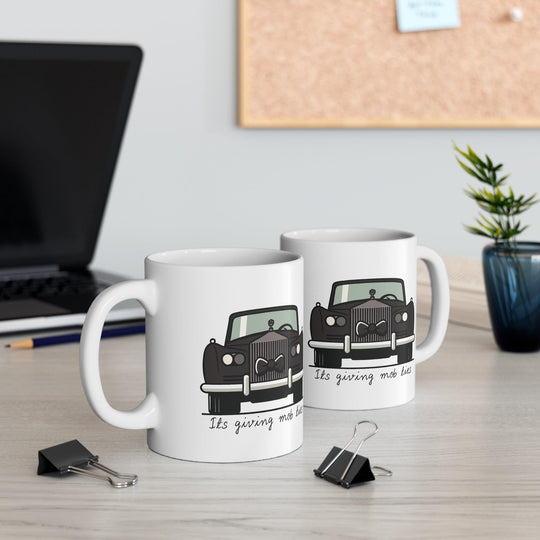 White ceramic mug featuring a black car design with the phrase 'It's Giving Mob Ties,' perfect for anyone with a love for mob-inspired humor.