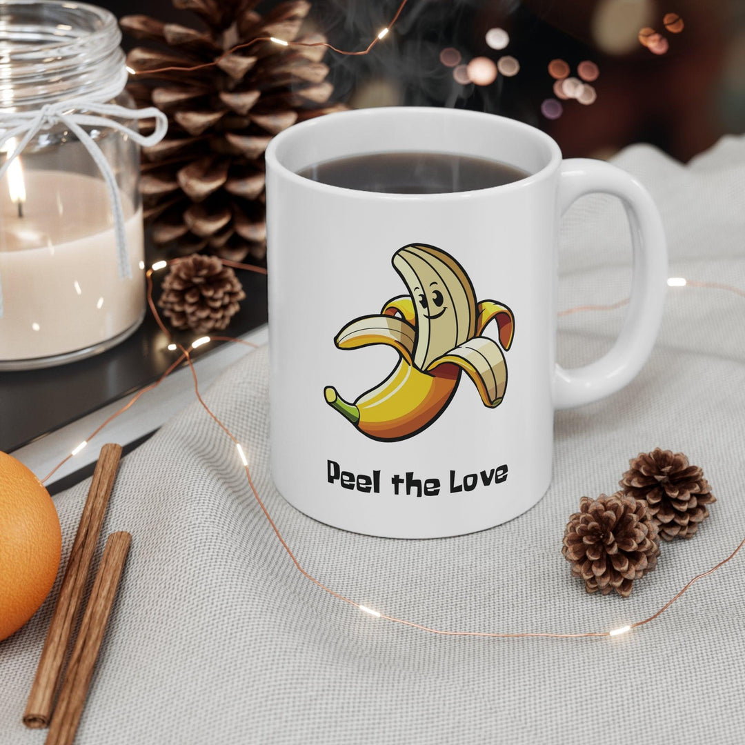 Fun white ceramic mug featuring a smiling cartoon banana and the playful text 'Peel the Love,' ideal for spreading positivity with a cute design