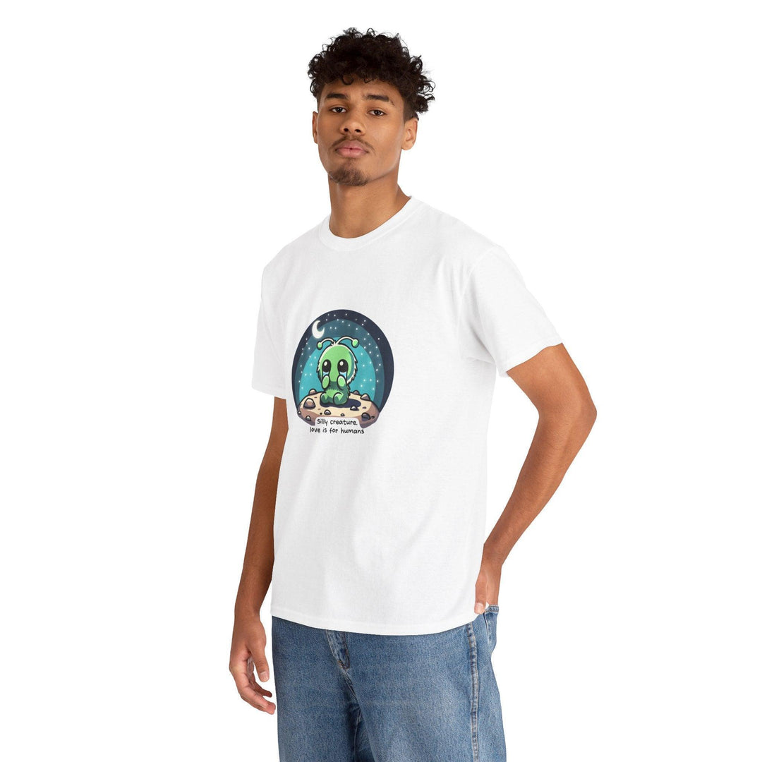 White unisex T-shirt featuring an alien creature under a starry sky with the phrase 'Silly Creature, Love Is for Humans.' A whimsical and slightly cynical design for sci-fi lovers with a unique sense of humor.