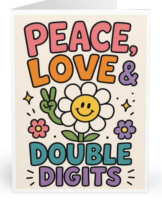 A folded greeting card shown upright on a white background. The front features a retro-style illustration with the words “PEACE, LOVE &amp; DOUBLE DIGITS” in large colorful letters around a smiling daisy flower.