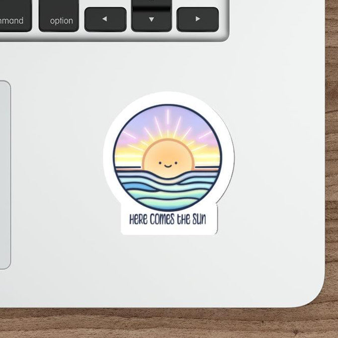 Colorful and uplifting waterproof sticker featuring a rising sun with the words 'Here Comes The Sun.' A bright and cheerful addition to laptops, water bottles, or notebooks  KEOLIX 
