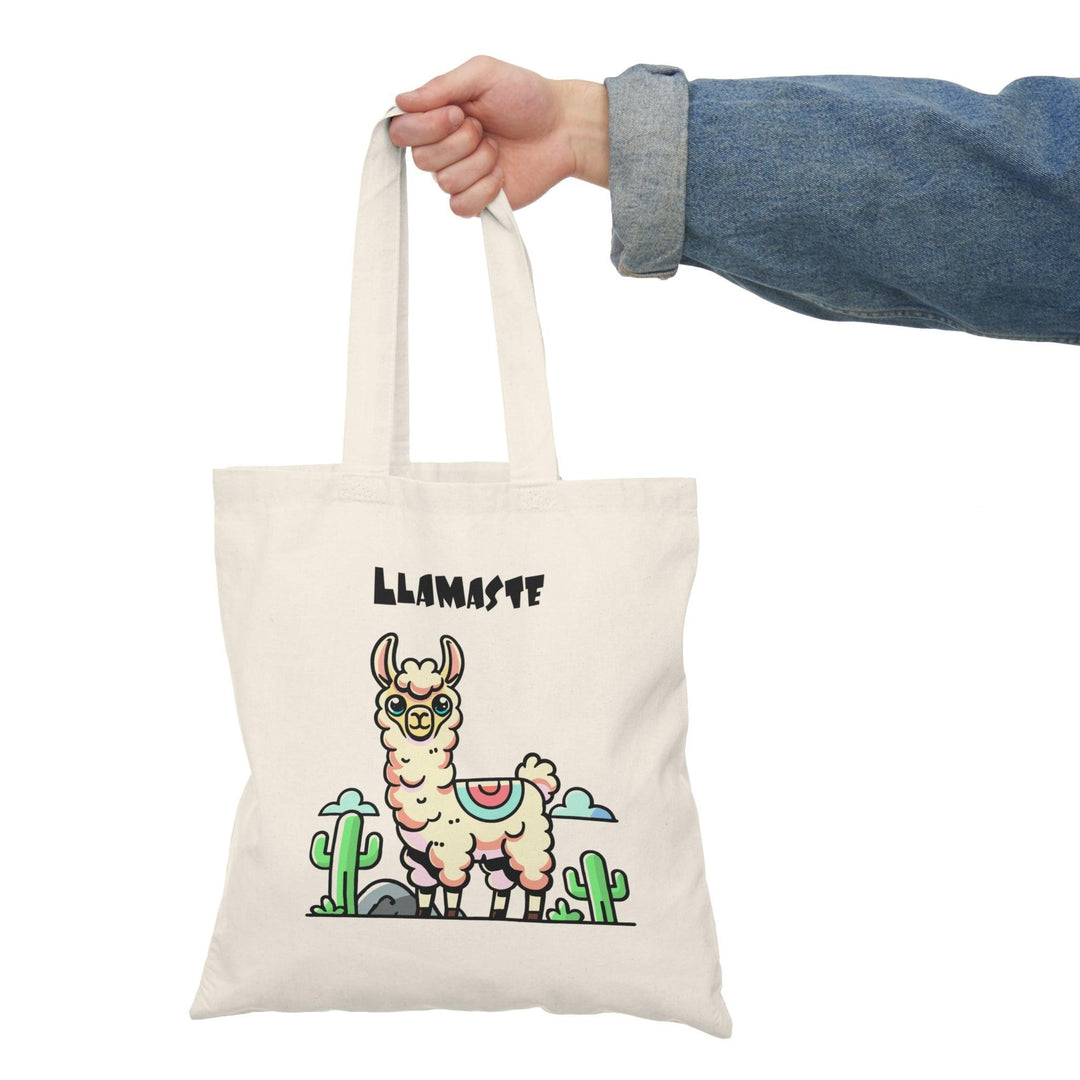 A natural tote bag featuring a whimsical illustration of a llama doing yoga with the text 'Llamaste' in bold letters. The lighthearted design merges fitness with humor, making it a great accessory for yoga lovers or anyone looking to add a bit of fun to their collection