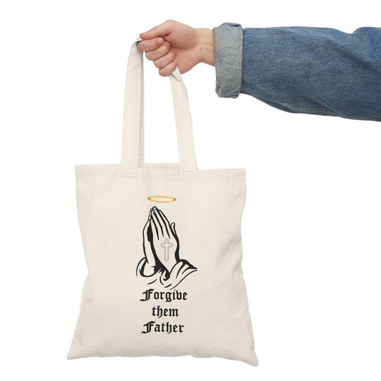 Tote bag made from 100% recycled cotton, featuring a striking design of a cross with a halo, accompanied by the impactful phrase 'Forgive Them Father.' Measuring 40 x 38cm (15.7 x 15 inches) and weighing 130-135 gsm, this lightweight yet sturdy bag is perfect for daily essentials, making a meaningful statement about forgiveness and eco-conscious living."
