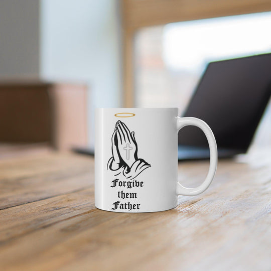 Classic white ceramic mug featuring praying hands and the text 'Forgive Them Father,' ideal for those who appreciate faith-inspired designs