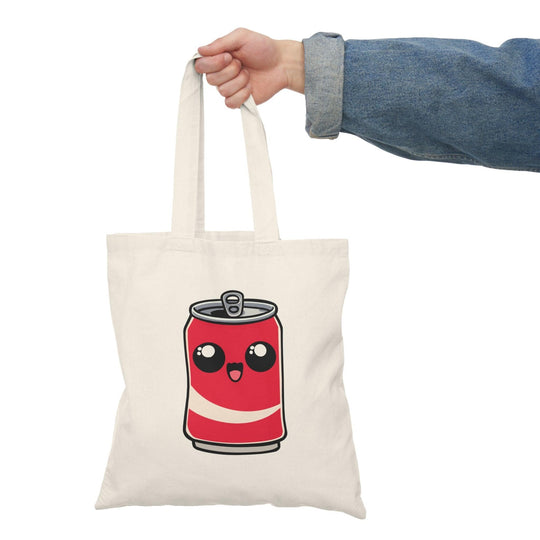 Tote bag featuring a playful illustration of a cute cartoon soda can, complete with a smiling face and vibrant colors. This fun design adds a lively touch to your everyday carry, making it an ideal accessory for soda lovers and anyone looking to express their playful style.