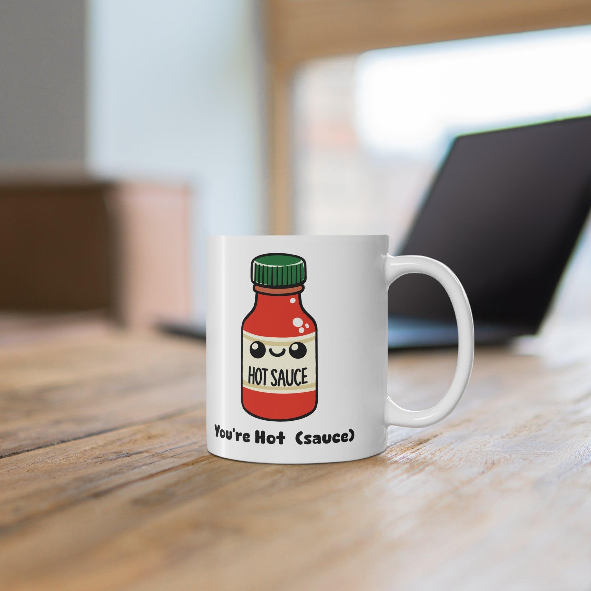 'You're Hot (Sauce)' Mug - "White ceramic mug featuring a hot sauce bottle illustration with the playful text 'You're Hot (Sauce),' perfect for adding spice to your drinkware collection."

