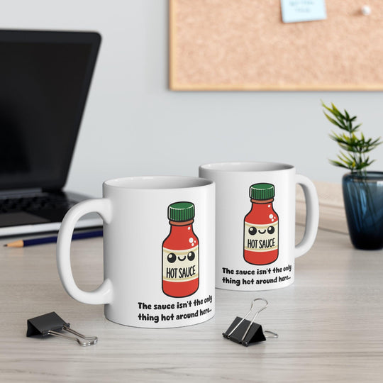 Fun white ceramic mug with a cute hot sauce bottle illustration and the flirty phrase 'You know I can't resist the only thing hot around here,' perfect for adding spice to your morning routine