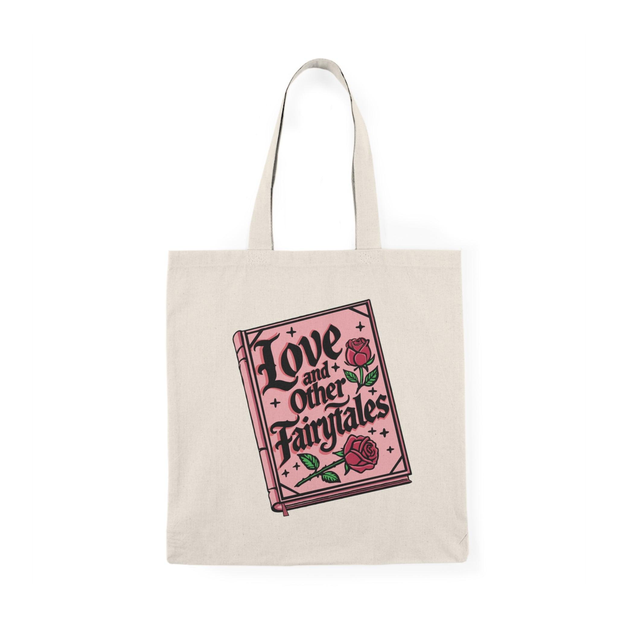 A natural canvas tote bag featuring a whimsical illustration with the text 'Love and Other Fairytales' surrounded by decorative elements. The enchanting design evokes a sense of magic and romance, making it an ideal accessory for dreamers and romantics