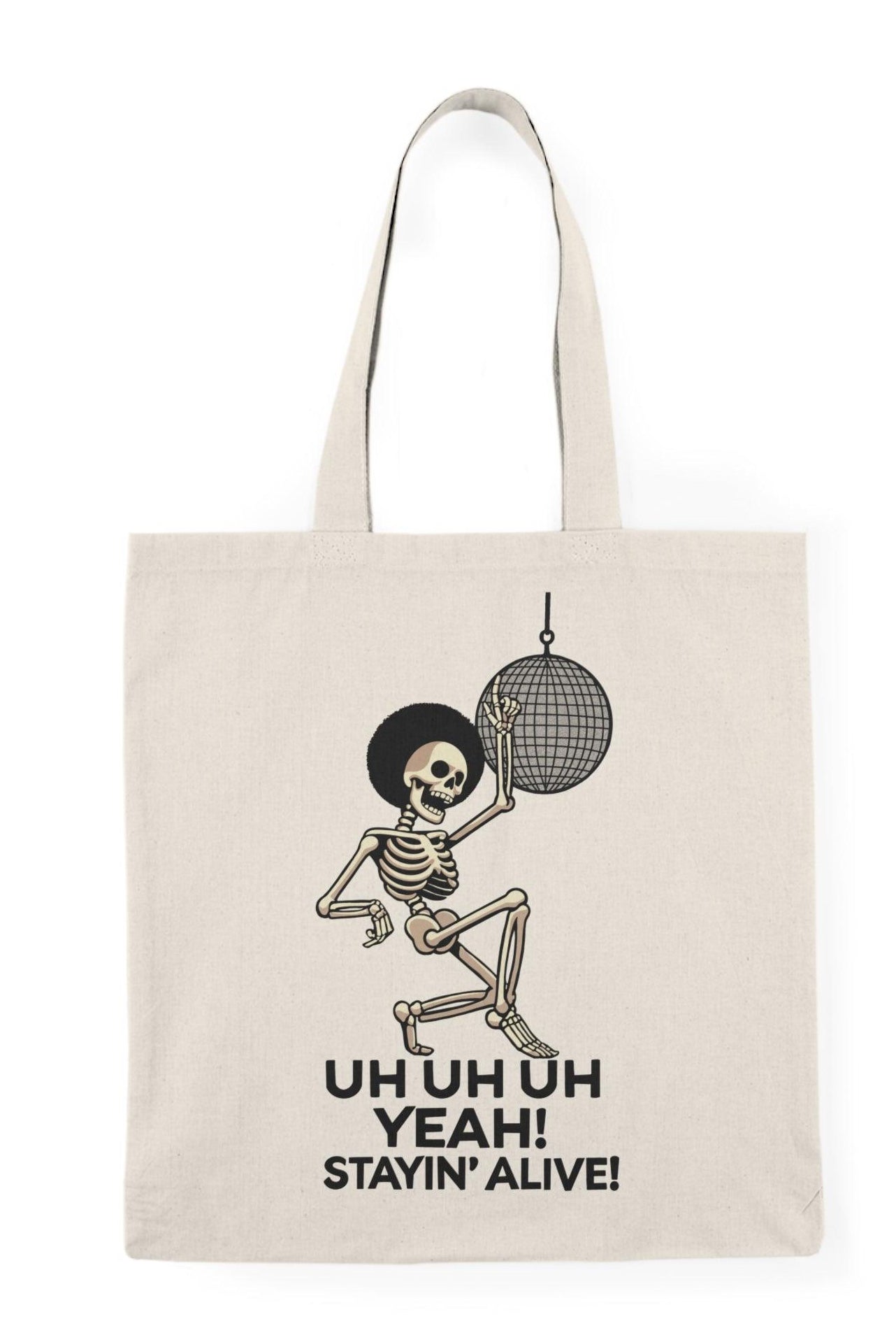 A cream-colored tote bag featuring a fun graphic of a dancing skeleton with the text 'Uh Uh Oh Yeah! Stayin' Alive.' The playful design captures a lighthearted spirit and a classic disco vibe, perfect for music lovers and those who appreciate quirky accessories.