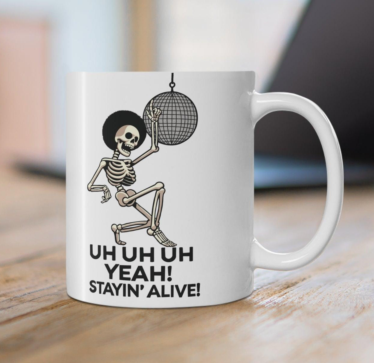 White ceramic mug with a disco-themed illustration and the text 'Stayin' Alive,' a fun, nostalgic nod to classic dance tunes