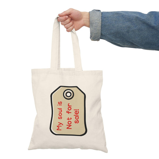 A cream tote bag featuring a minimalist design with a price tag graphic and the text 'My Soul is Not for Sale.' The straightforward message combined with a clean aesthetic conveys a strong statement about self-worth and individuality.