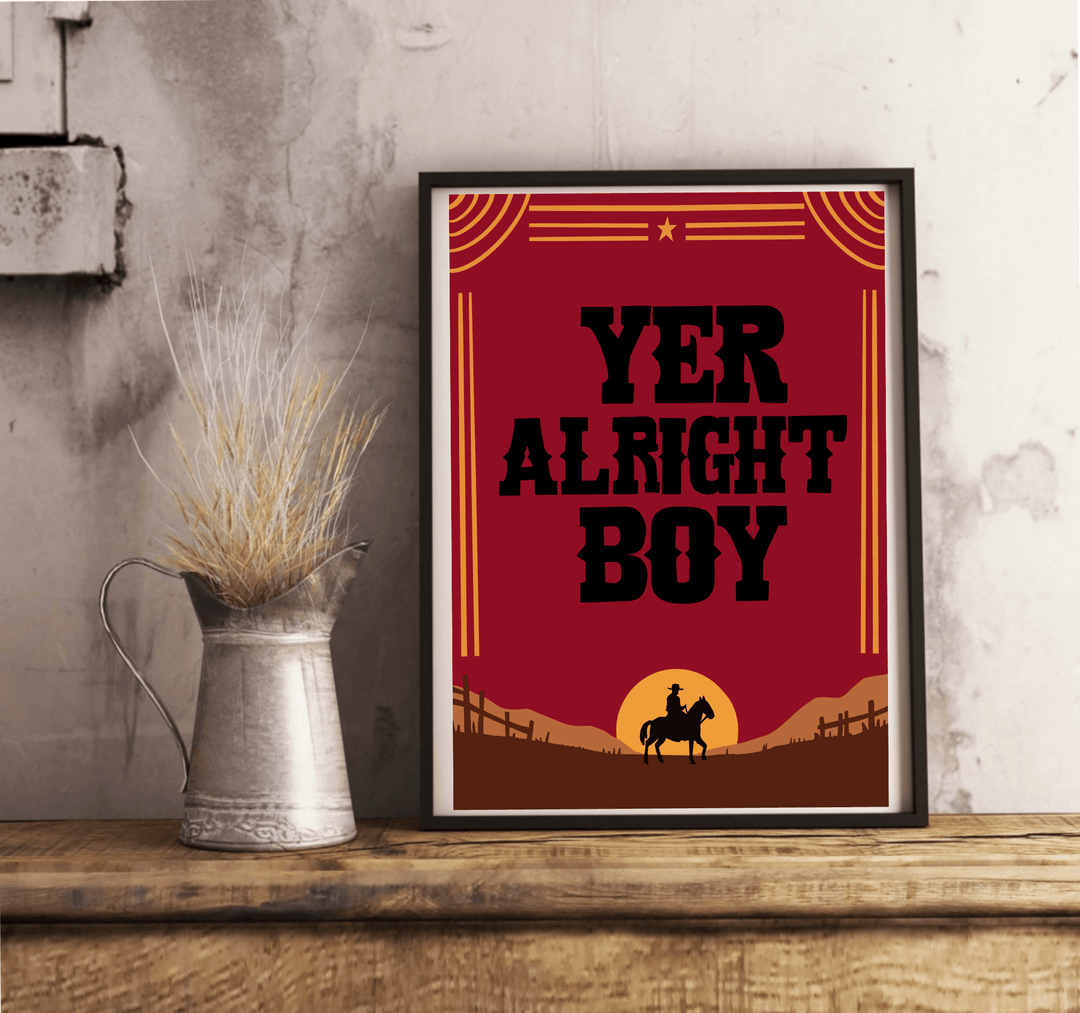 Introducing the "Yer Alright Boy" print—a charming piece that's sure to add a touch of personality to any space! Framed and elegantly displayed on a rustic wooden floor, this artwork showcases bold black letters confidently declaring "YER ALRIGHT BOY." The design features the striking silhouette of a horse and rider, standing proudly against a rich brown landscape dotted with quaint fences. Decorative lines and a star add an extra flair to this captivating scene, all set against a classic white wall. Perfec