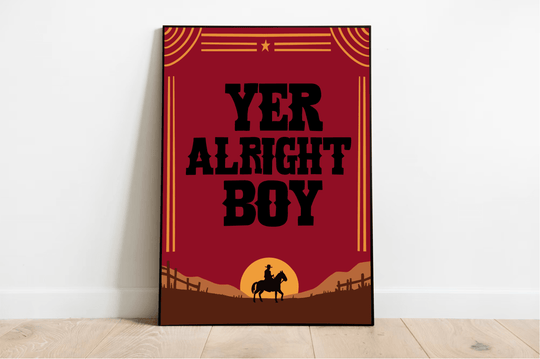 Introducing the "Yer Alright Boy" print—a charming piece that's sure to add a touch of personality to any space! Framed and elegantly displayed on a rustic wooden floor, this artwork showcases bold black letters confidently declaring "YER ALRIGHT BOY." The design features the striking silhouette of a horse and rider, standing proudly against a rich brown landscape dotted with quaint fences. Decorative lines and a star add an extra flair to this captivating scene, all set against a classic white wall. Perfec