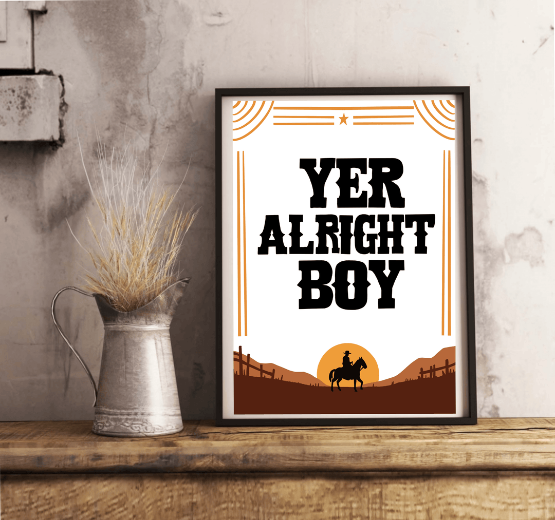 Introducing the "Yer Alright Boy" print—a charming piece that's sure to add a touch of personality to any space! Framed and elegantly displayed on a rustic wooden floor, this artwork showcases bold black letters confidently declaring "YER ALRIGHT BOY." The design features the striking silhouette of a horse and rider, standing proudly against a rich brown landscape dotted with quaint fences. Decorative lines and a star add an extra flair to this captivating scene, all set against a classic white wall. Perfec