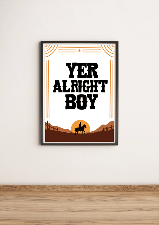 Introducing the "Yer Alright Boy" print—a charming piece that's sure to add a touch of personality to any space! Framed and elegantly displayed on a rustic wooden floor, this artwork showcases bold black letters confidently declaring "YER ALRIGHT BOY." The design features the striking silhouette of a horse and rider, standing proudly against a rich brown landscape dotted with quaint fences. Decorative lines and a star add an extra flair to this captivating scene, all set against a classic white wall. Perfec