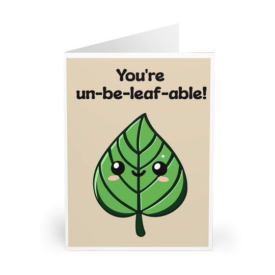 A greeting card with a cartoon leaf character with eyes and a smiling face, and the text &