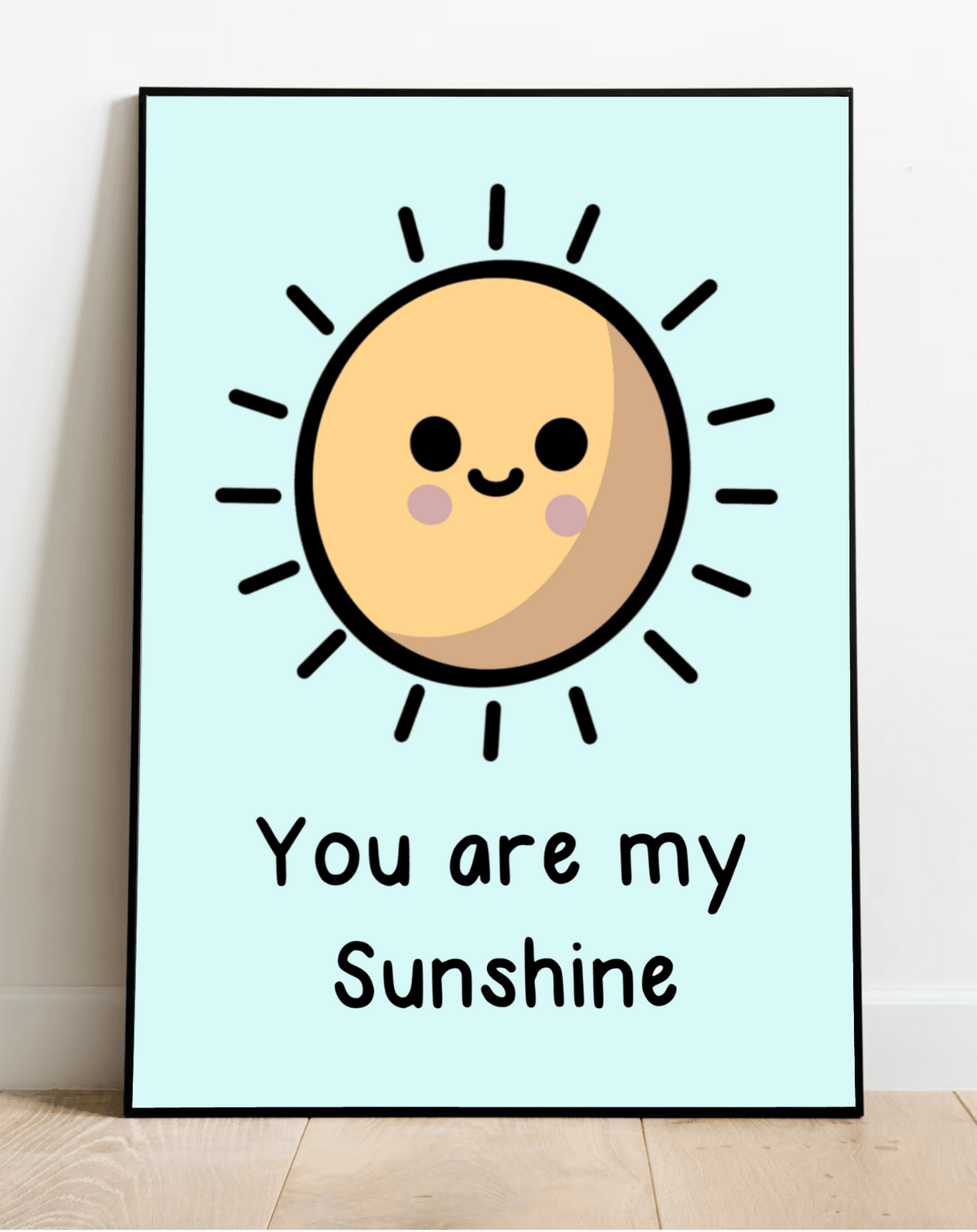 Brighten up your space with our charming "You are my Sunshine" framed print! This delightful piece features a cartoon sun with adorable rosy cheeks against a serene light blue background. Its lively black rays and joyful text add a cheerful touch, perfect for any room. Displayed leaning effortlessly against a white wall on a cozy wooden floor, it's sure to bring smiles and warmth to your home decor!