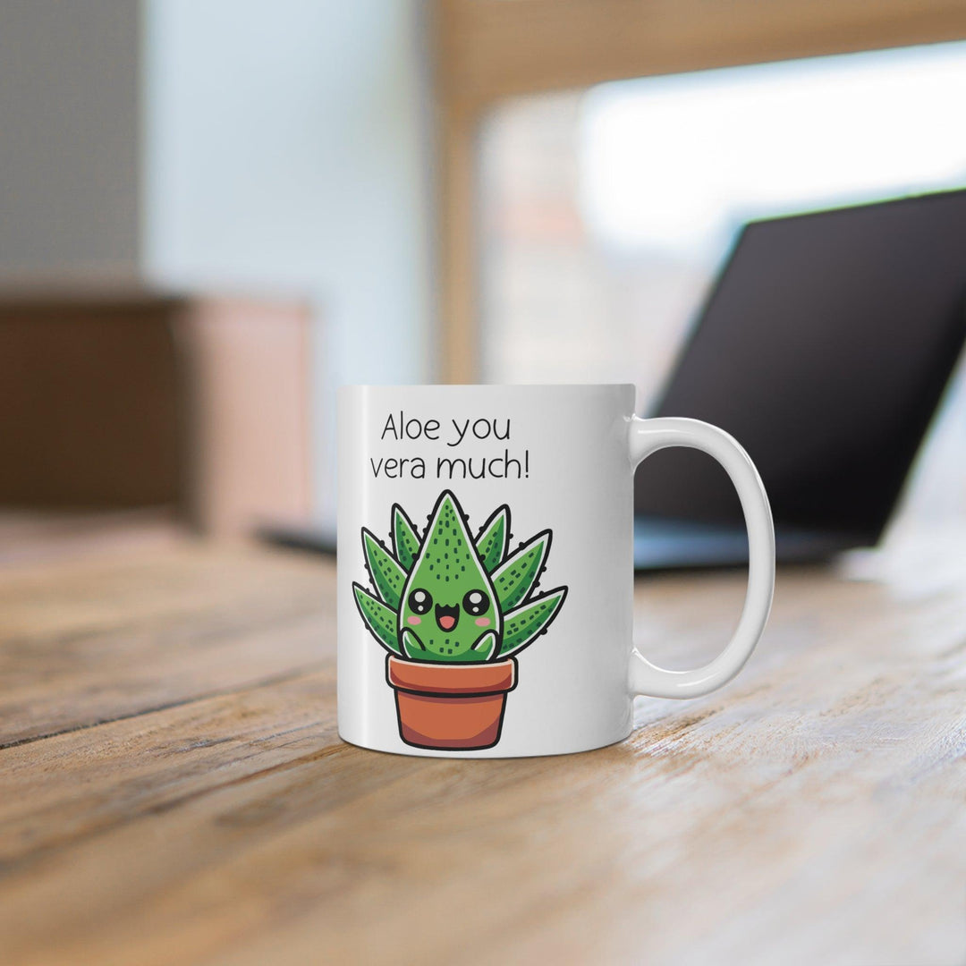 un white ceramic mug featuring an adorable aloe plant illustration with the witty phrase 'Aloe You Vera Much,' styled with a wintery, cozy setup