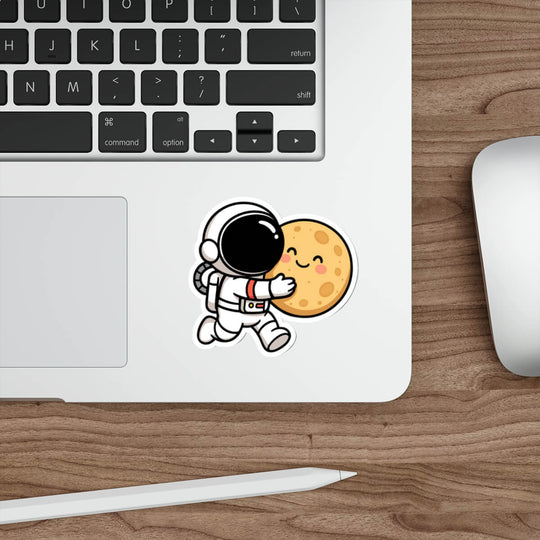Cute vinyl sticker of a cartoon astronaut hugging a smiling moon, placed on a skateboard deck.