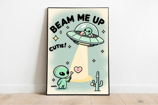 A "Beam Me Up, Cutie" waterproof sticker from Baby Keo adorns a wooden gift box with a green ribbon, placed on a festive table amidst holiday ornaments and gingerbread cookies. The sticker features whimsical artwork of a cartoon baby alien alongside the text, "This gift is outta this world," inviting you on a cosmic adventure.