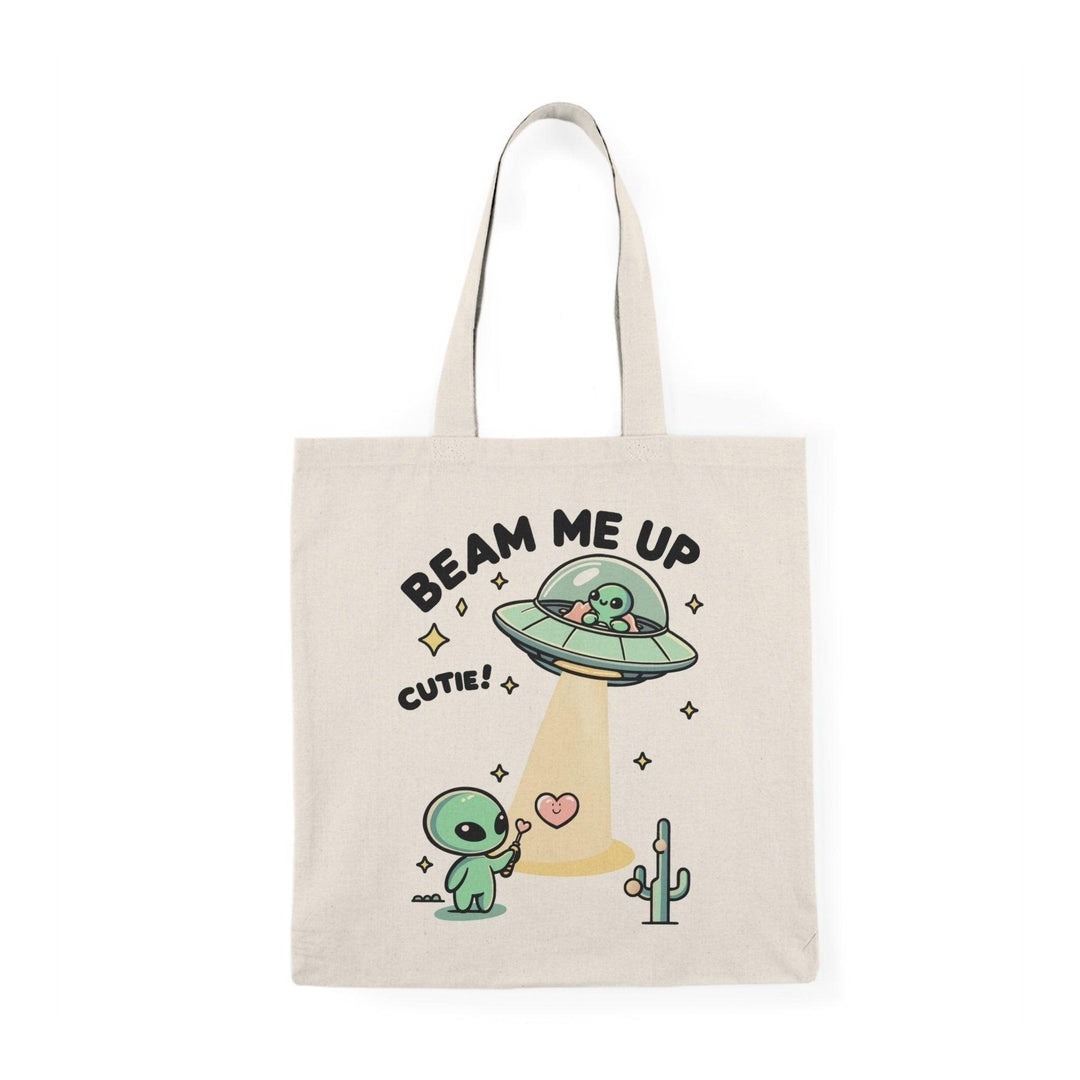 Tote bag featuring a whimsical design with the phrase 'Beam Me Up, Cutie' alongside a charming illustration of a cute alien. The colorful and playful graphics create a fun and quirky vibe, making it an ideal accessory for those who love all things cosmic and adorable."